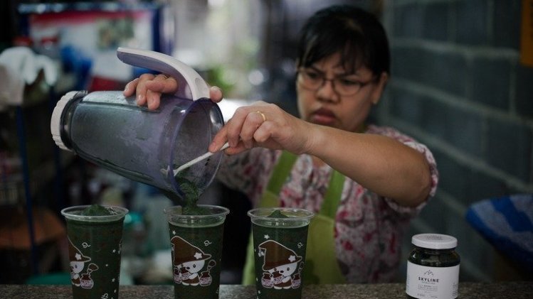A woman prepares a spirulina shake in Bangkok on June 24, 2013