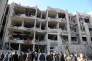 In this photo released by the Syrian official news agency SANA, Syrian security officers investigate a damaged building of the air intelligence forces, which was attacked by one of two explosions, in Damascus, Syria, on Saturday, March 17, 2012. Two 