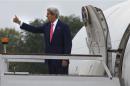 U.S. Secretary of State Kerry gestures as he boards his aircraft to depart London