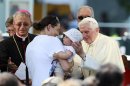Pope Benedict XVI blesses a child as he visits the damaged church of St. Catherine of Alexandria in Rovereto di Novi
