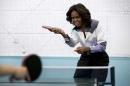 U.S. first lady Michelle Obama plays table tennis at the Beijing Normal School, a school that prepares students to attend colleges overseas in Beijing, China Friday, March 21, 2014. (AP Photo/Andy Wong, Pool)
