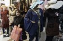 In this Saturday, March 17, 2012 photo, an Iranian woman leaves a shop after purchasing clothes in Tehran, Iran. The Iranian New Year or Nowruz, meaning 