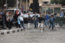 Egyptian protesters throw stones during a clash outside the US embassy in Cairo, Egypt, Friday, March 9, 2012. Several hundred protesters gathered Friday outside the U.S. Embassy in Cairo, raising their shoes at a picture of President Barack Obama and calling on Egypt to expel Washington's ambassador amid a heated national debate about the trial of Americans working with pro-democracy groups who have been charged with using foreign funding to foment unrest. (AP Photo)