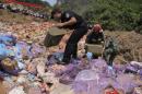Police officers pour gasoline on confiscated smuggled meat before setting it on fire during a massive destruction campaign in Hekou county