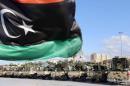 The national flag flutters as Libyan security gather in the capital Tripoli on September 21, 2013
