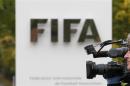 A cameraman films in front of the main entrance of the Home of FIFA in Zurich