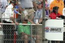In this photo provided by Fernando Echeverria, security personnel assist a fan injured by a broken television camera cable during the NASCAR Sprint Cup series Coca-Cola 600 auto race at Charlotte Motor Speedway in Concord, N.C., Sunday, May 26, 2013. (AP Photo/Fernando Echeverria)
