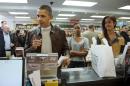 President Barack Obama, with daughters Sasha, center, and Malia, pays for his purchase the the local bookstore Politics and Prose in northwest Washington, Saturday, Nov. 30, 2013. (AP Photo/Manuel Balce Ceneta)