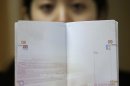 A woman holds a Chinese passport in Wuhan