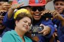 Brazil's President Rousseff takes a selfie with workers during a visit to the Rio 2016 Olympic Park in Rio de Janeiro