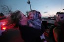 Sandy Ryan, holds her granddaughter, Maci Becraft, in Metro Piner, Ky., after a tornado swept through the area Friday, March, 2, 2012. The front of Becraft's house was destroyed due to the tornado and Ryan is attempting to locate other Becraft family members. Powerful storms stretching from the U.S. Gulf Coast to the Great Lakes in the north wrecked two small towns, killed over a dozen, and bred anxiety across a wide swath of the country on Friday, in the second deadly tornado outbreak this week. (AP Photo/The Cincinnati Enquirer, Carrie Cochran) MANDATORY CREDIT; NO SALES