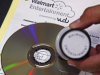 A "Walmart Entertainment" stamp in indelible ink has been placed on a disc, preventing any further conversion, but allowing it to still be played, at a Wal-Mart store in Rosemead, Calif., Wednesday, April 11, 2012. Wal-Mart is set to unveil its "disc-to-digital" service for converting old DVDs into an online library that is available over the Internet. The fee it will charge per disc is meant to cover the cost of hosting and delivering reams of movie files to various devices. The world's largest retailer also aims to keep drawing customers to its big-box stores as their movie-watching habits change. (AP Photo/Reed Saxon)