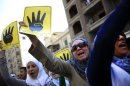 Supporters of Egypt's ousted President Mohammed Morsi chant slogans and hold placards showing an open palm with four raised fingers, which has become a symbol of the Rabaah al-Adawiya mosque, where Morsi supporters had held a sit-in that was violently dispersed on August, 2013, during a protest in Cairo, Egypt, Friday, Sept. 6, 2013. Thousands of protesters flowed out of mosques on Friday in Muslim Brotherhood-led rallies across the country against the military-backed government a day after a car bomb in the Egyptian capital marked a substantial escalation in Egypt's violent turmoil.(AP Photo/Khalil Hamra)