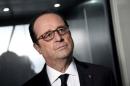French President Francois Hollande listens during his visit to the French elevators company ETNA France in Taverny