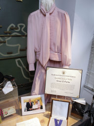 In this July 25, 2011 photo, the Presidential Medal of Freedom presented to Rosa Parks by President Bill Clinton on Sept. 9, 1996, its certificate, and the dress she wore for the occasion, are shown in this is photo at Guernsey's auction house, in New York. (AP Photo/Richard Drew)