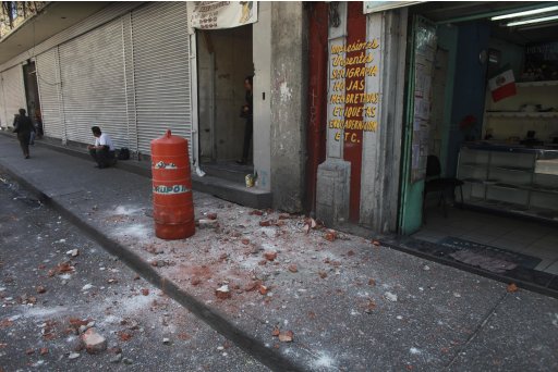 A woman leaves a building that suffered some damage after an earthquake was felt in Mexico City, Tuesday March 20, 2012. A strong, long earthquake with epicenter in Guerrero state shook central southern Mexico, swaying buildings in Mexico City and sending frightened workers and residents into the streets. (AP Photo/Dario Lopez-Mills