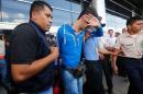 Honduran policemen escort one of five Syrian citizens arrested at the Tocontin international airport in Tegucigalpa on November 18, 2015