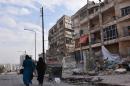 Syrians walk through the former rebel-held Zebdiye district in the northern Syrian city of Aleppo on December 23, 2016