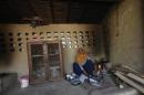 A woman cooks "roti" on an earthen stove inside a farm house near the Jhajjar district