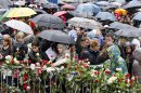 People lays flowers near the entrance the courthouse in Oslo where Anders Behring Breivik is standing trial Thursday April 26, 2012. Nearly 40,000 people who turned up in poor weather at the Youngstorget Square in Oslo to participate in the singing of 