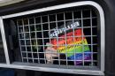 A Russian LGBT rights activist shows a sign reading "Love is stronger than homophobia" from inside a riot police van during an unauthorized gay rights rally in Moscow on May 25, 2013