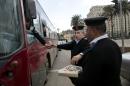 Egyptian policemen give out chocolates to citizens marking Police Day, which falls on Jan. 25, the anniversary of the 2011 uprising that toppled longtime ruler Hosni Mubarak in Tahrir Square, Cairo, Egypt, Sunday, Jan. 24, 2016. (AP Photo/Roger Anis)