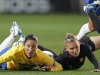 Daiane Menezes, left, of Brazil and Amy Rodriguez of the United States fall on the ground while battling for the ball during their Kirin Challenge Cup women's friendly soccer match in Chiba, eastt of Tokyo, Tuesday, April 3, 2012. (AP Photo/Koji Sasahara)