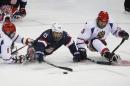 United States' Nikki Landeros, center, in action with Russia's Konstantin Shikhov, left, and Vasilii Varlakov during an ice sledge hockey match between United States and Russia at the 2014 Winter Paralympics in Sochi, Russia, Tuesday, March 11, 2014. Russia won 2-1. (AP Photo/Pavel Golovkin)