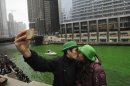 John Shepard and Gena Damento of Rochester Minn., take a photo of themselves kissing after the Chicago River was dyed green ahead of the St. Patrick's Day parade in Chicago, Saturday, March, 16, 2013. With the holiday itself falling on a Sunday, many celebrations were scheduled instead for Saturday because of religious observances. (AP Photo/Paul Beaty)