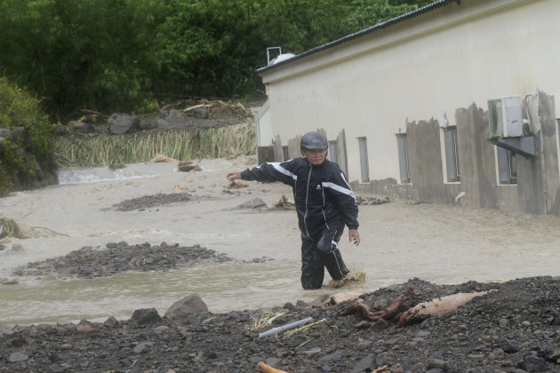 A Taiwanese man wades through a flash flood triggered by typhoon Nanmadol in Manchu, Pingtung County, Southern Taiwan, Monday, Aug. 29, 2011. Nanmadol slammed into Taiwan, closing schools, workplaces 