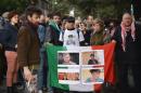 Protesters hold an Italian flag with photos of Giulio Regeni, during a demonstration in front of the Egypt's embassy in Rome, on February 25, 2016