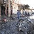 Iraqi security forces inspect the site of a bomb attack in Hilla