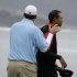 Dallas Cowboys quarterback Tony Romo, left, puts his hands on the shoulders of Tiger Woods on the 18th green at Pebble Beach Golf Links during the final round of the AT&T Pebble Beach National Pro-Am golf tournament in Pebble Beach, Calif., Sunday, Feb. 12, 2012. (AP Photo/Eric Risberg)
