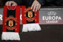 A Manchester United supporter adjusts a club scarf before their Europa League soccer match against Ajax in Manchester