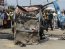 People gather near a burnt commercial bus, where a bomb exploded, along a road in Rumuokoro district in Nigeria's oil hub city of Port Harcourt