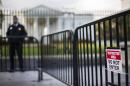 A US Secret Service Uniformed Division officer stands between the temporary barricade and the fence line of the White House in Washington, DC, October 23, 2014