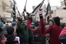 Free Syrian Army fighters cheer during an anti-Syrian regime protest in Maarat Al-Nouman
