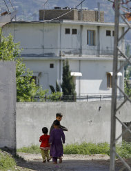FILE - In this May 8, 2011 file photo, Pakistani children walk past the house of former al-Qaida leader Osama bin Laden in Abbottabad, Pakistan. After Navy SEALs killed Osama bin Laden, the White House released a photo of President Barack Obama and his cabinet inside the Situation Room, watching the daring raid unfold. Hidden from view, standing just outside the frame of that instantly iconic photograph was a career CIA analyst. In the hunt for the world's most-wanted terrorist, there may have been no one more important. His job for nearly a decade: finding bin Laden. (AP Photo/Anjum Naveed, File)