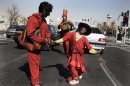 In this Monday, March 19, 2012 photo, Iranians, wearing red clothes and black make-up, as a symbol of the Iranian New Year, called Haji Firouz, sing and dance in a street, hoping to earn money from passers-by in northern Tehran, Iran. The Iranian New Year or Nowruz, meaning 