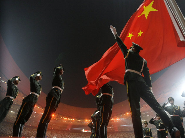 Chinese military soldiers salute as the Chinese flag is raised during the Opening Ceremony for the Beijing 2008 Olympic Games in Beijing, Friday, Aug. 8, 2008. (AP Photo/Matt Dunham)