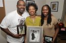 Handout photo of filmmaker Byron Hurt with his mother, Frances Hurt, and sister, Taundra Hurt, holding family photos of Hurt's father, Jackie Hurt, who died of pancreatic cancer