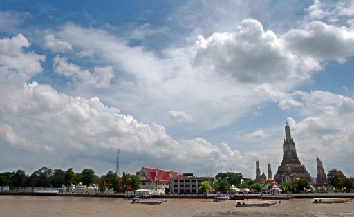 Thai motor boats sail on the Chao Phraya river along Wat Arun Buddhist temple in Bangkok, July 7, 2007