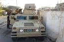 A man looks at a vehicle belonging to the Iraqi security forces in the Anbar province town of Hit