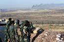 Kurdish Peshmerga forces keep watch in a village east of Mosul
