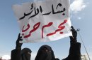 FILE - In this Sunday March 4, 2012 file photo, a Lebanese anti-Syrian regime Salafi protester, holds a poster in Arabic that reads, 