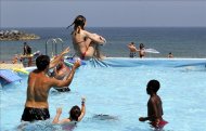 Varias personas disfrutan en una piscina. EFE/Archivo