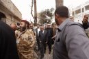 Libyan PM Zeidan walks out of a damaged house during a visit to the scene of an explosion in front of the French embassy in Tripoli
