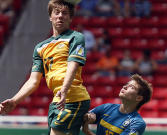 Adryan (embaixo) disputa a bola com defensor australiano