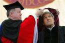 U.S. Secretary of State Kerry ducks as he receives an honorary Doctor of Laws degree from college president Leahy during Commencement Exercises at Boston College
