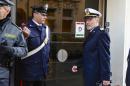 Coast Guard Capt. Gregorio De Falco, right, arrives at the Grosseto court, Italy, Monday, Dec. 9, 2013. A Italian Coast Guard official has testified that hundreds of people were still aboard the shipwrecked Costa Concordia when the commander abandoned the cruise liner in a lifeboat. Coast Guard Capt. Gregorio De Falco become a national hero after repeatedly ordering Francesco Schettino, the Concordia's commander on trial for manslaughter and abandoning ship, to return to the badly listing vessel. Schettino is also charged with causing the 2012 shipwreck by sailing too close to the Tuscan island of Giglio. A reef gashed the hull, water rushed in and 32 people died. (AP Photo/Giacomo Aprili)